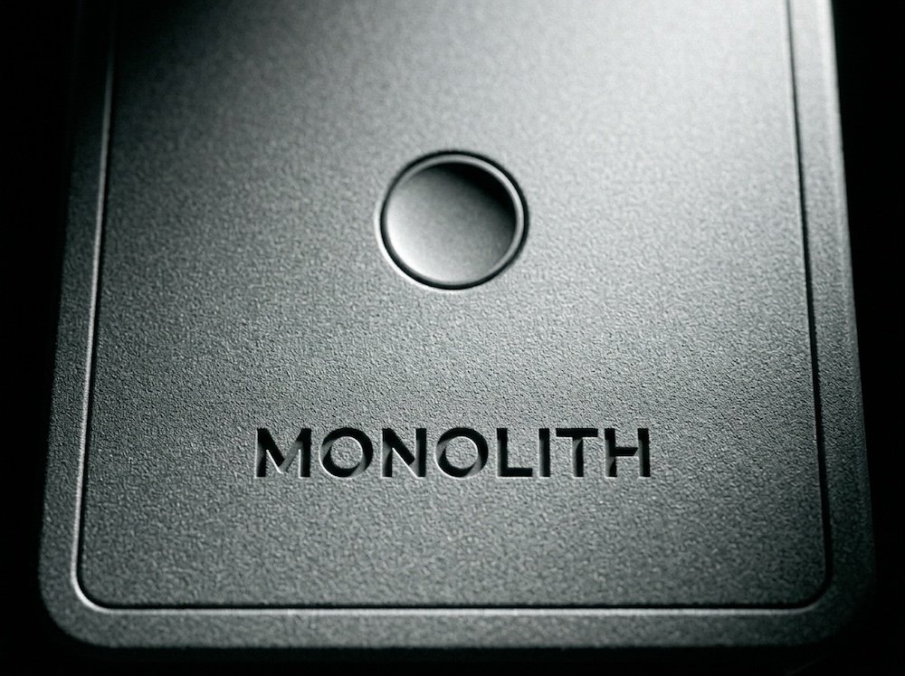 The MONOLITH speaker from a second angle under hard studio light.