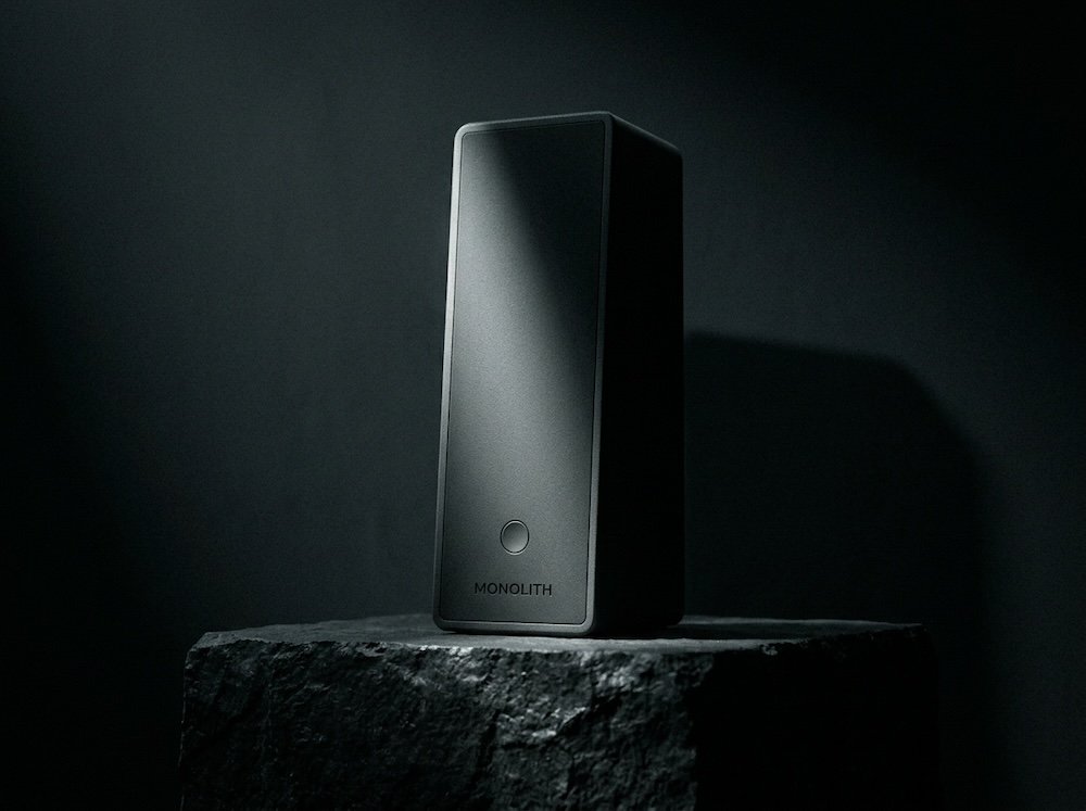 Macro of the MONOLITH speaker's cast front face and single button.
